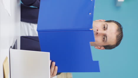 Vertical-video-of-Cheerful-businessman-working-on-files.